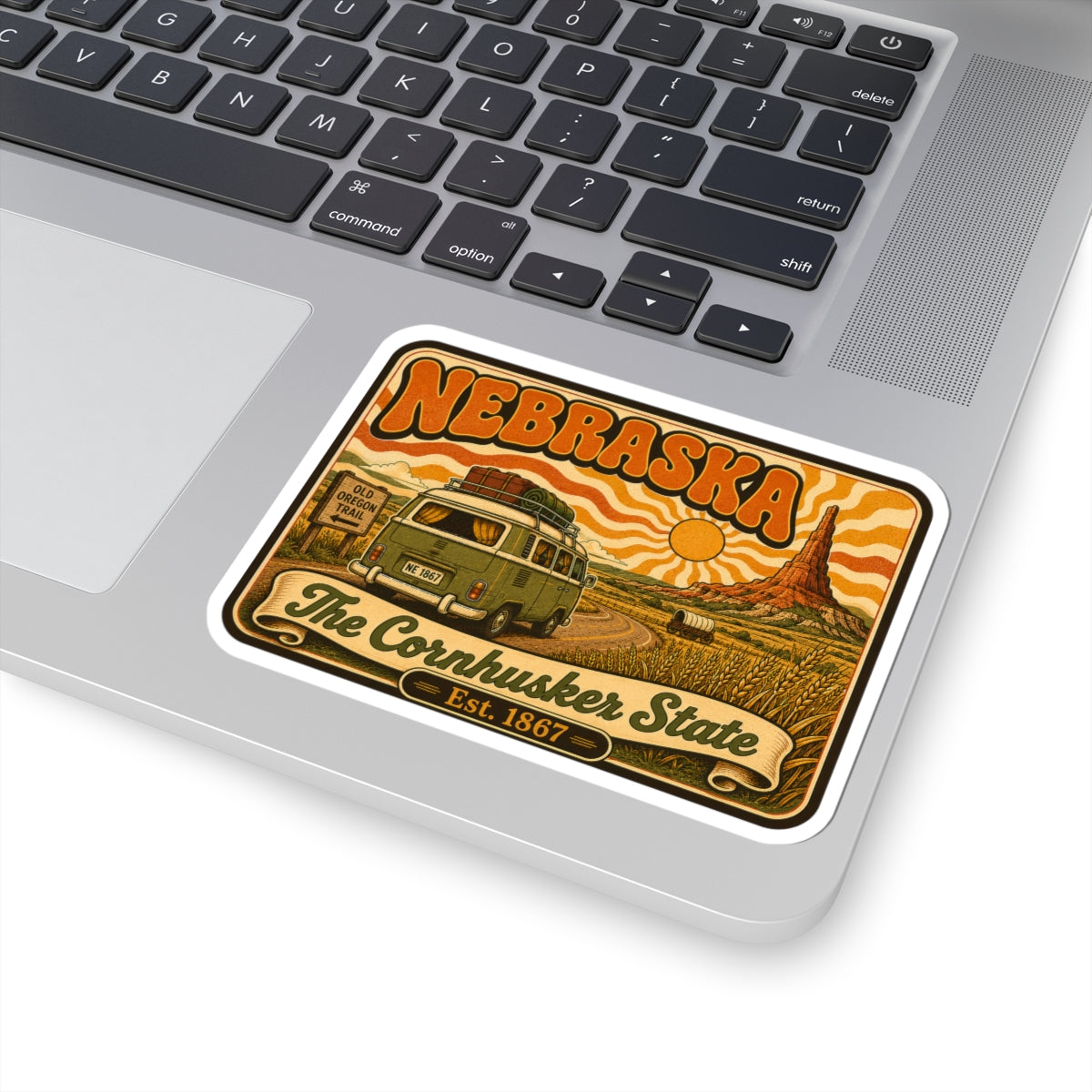 Nebraska vintage van kiss-cut sticker on laptop trackpad with cornfield and sun artwork