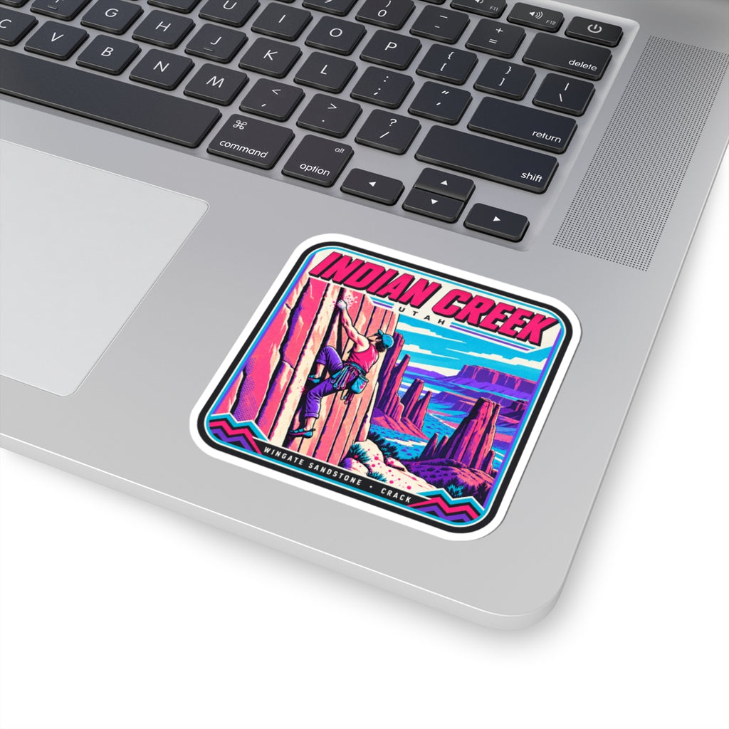 Square “INDIAN CREEK” sticker on a laptop keyboard with colorful climber and canyon graphic