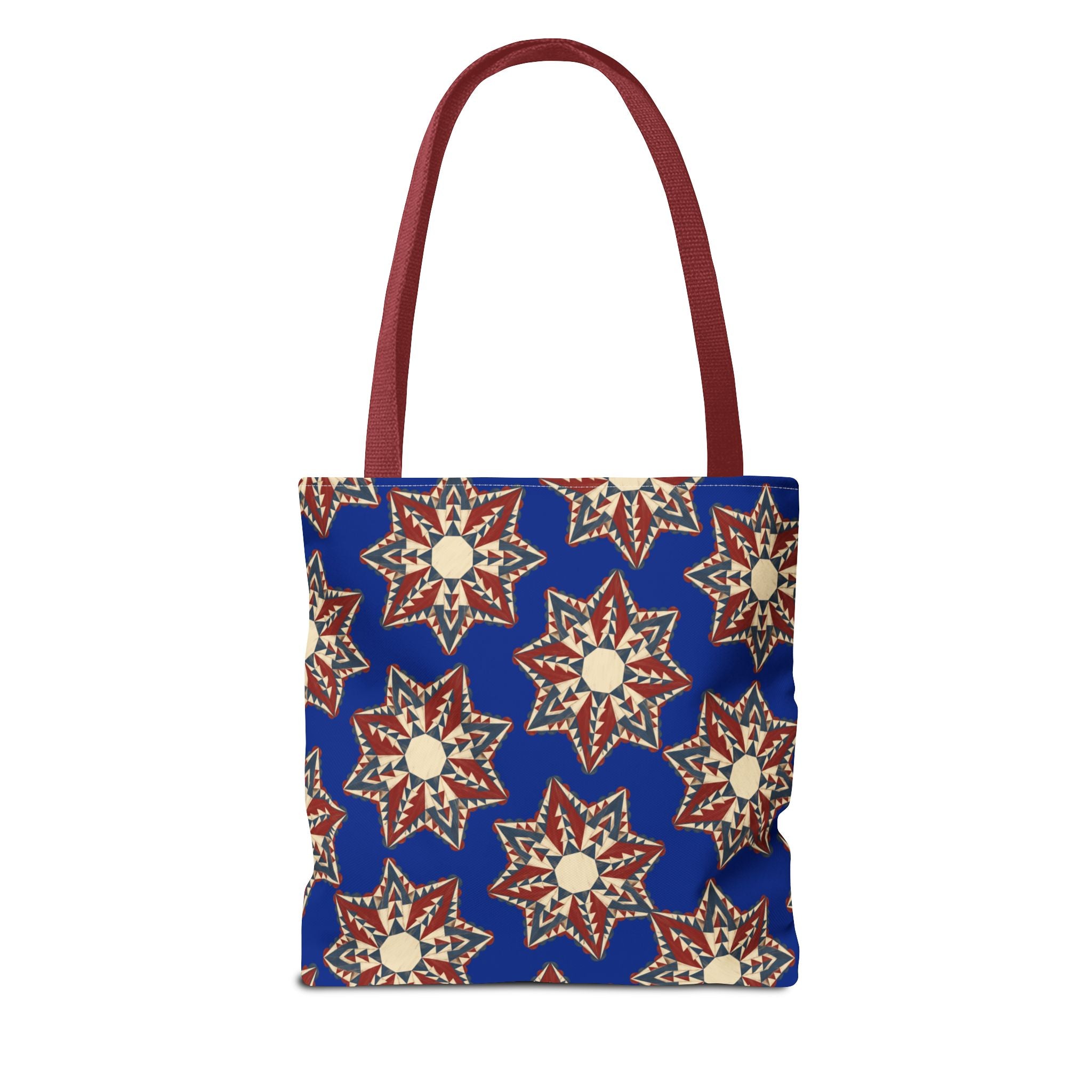 Blue tote bag with red and cream starburst floral pattern, red handles