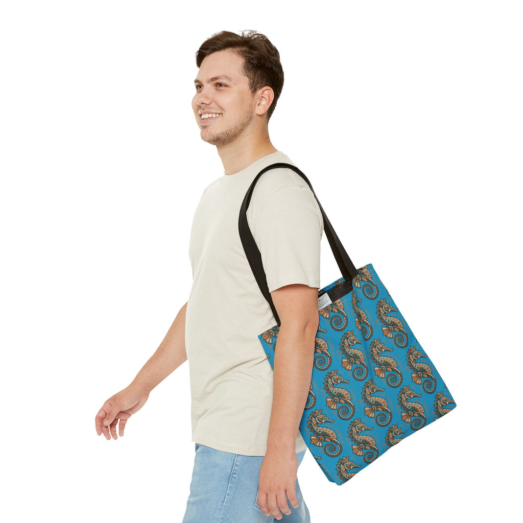 Ocean blue tote bag with steampunk seahorse pattern and black handles, worn on shoulder