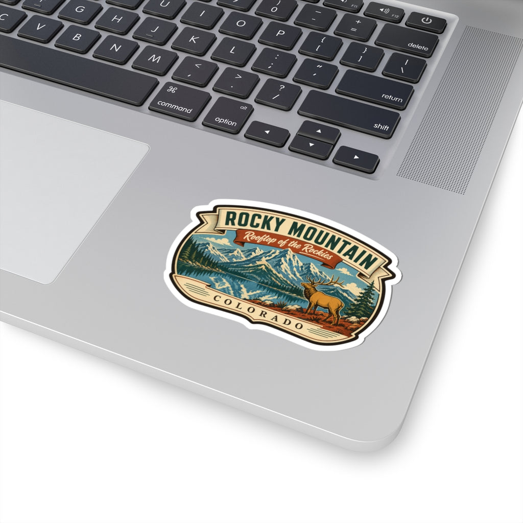 Travel sticker on a laptop lid, featuring Rocky Mountain lettering, elk, and Colorado