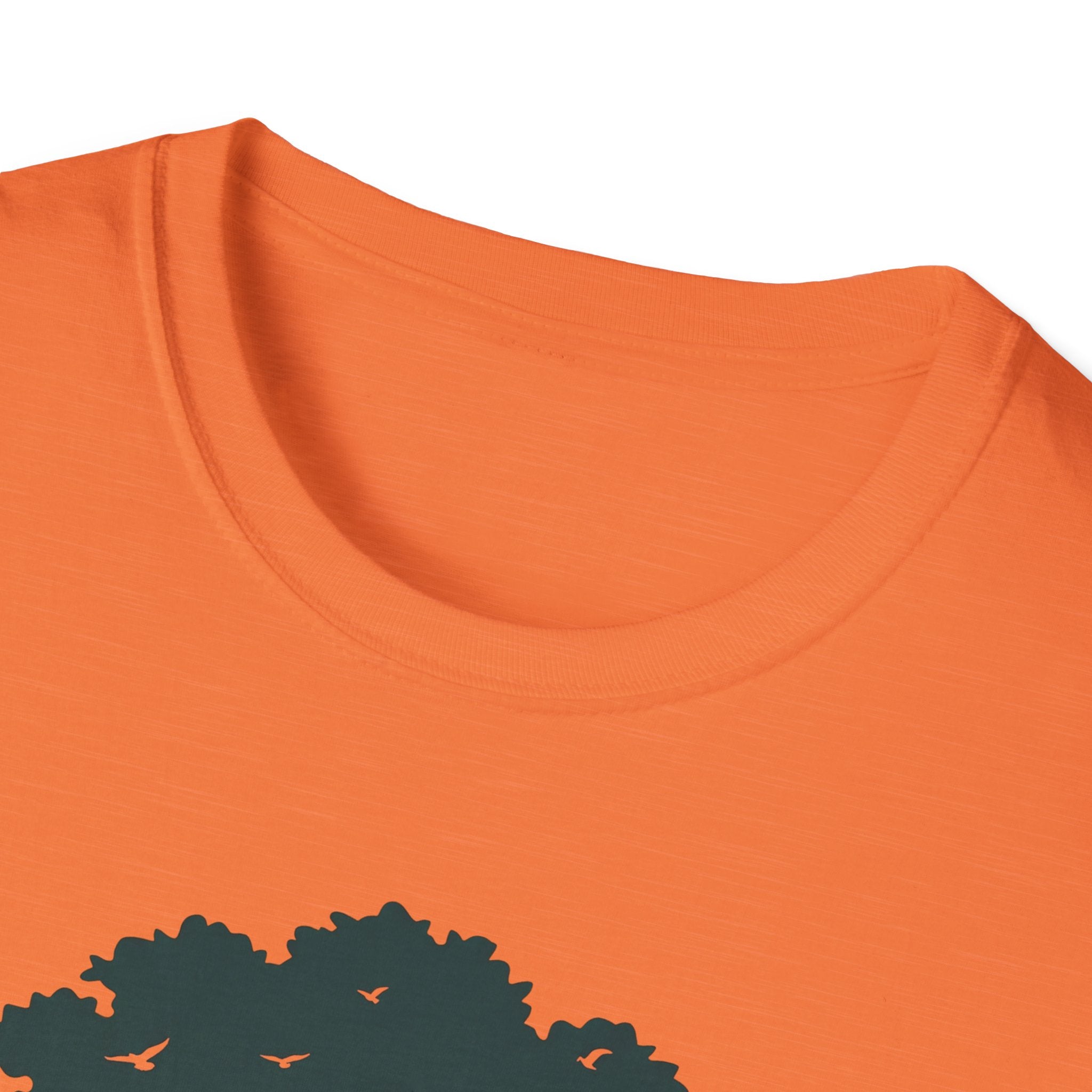 Orange T-shirt neckline and upper chest, part of the tree graphic visible
