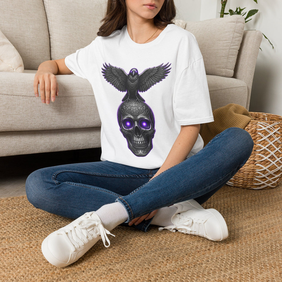 White graphic T-shirt worn by model featuring glowing purple raven skull and wings