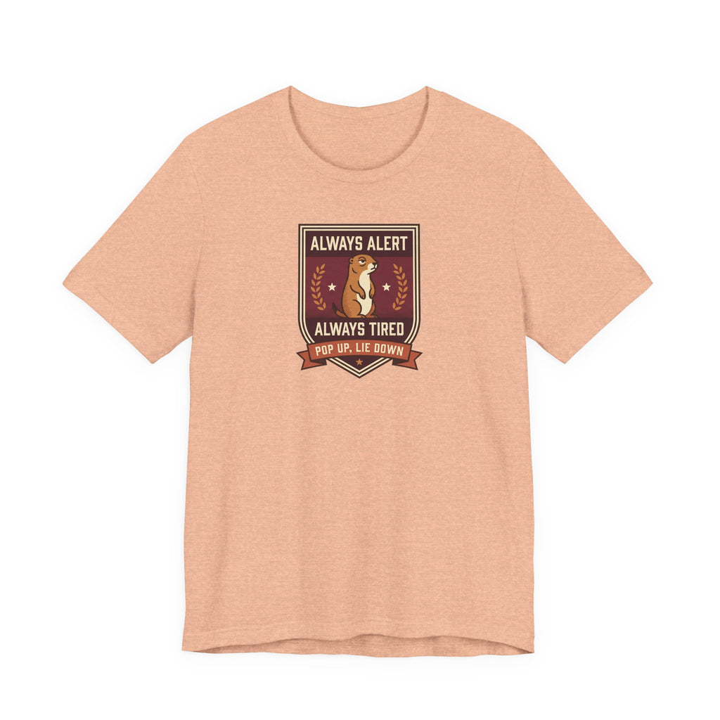 Peach T-shirt with squirrel crest badge graphic and “Always Alert Always Tired” text