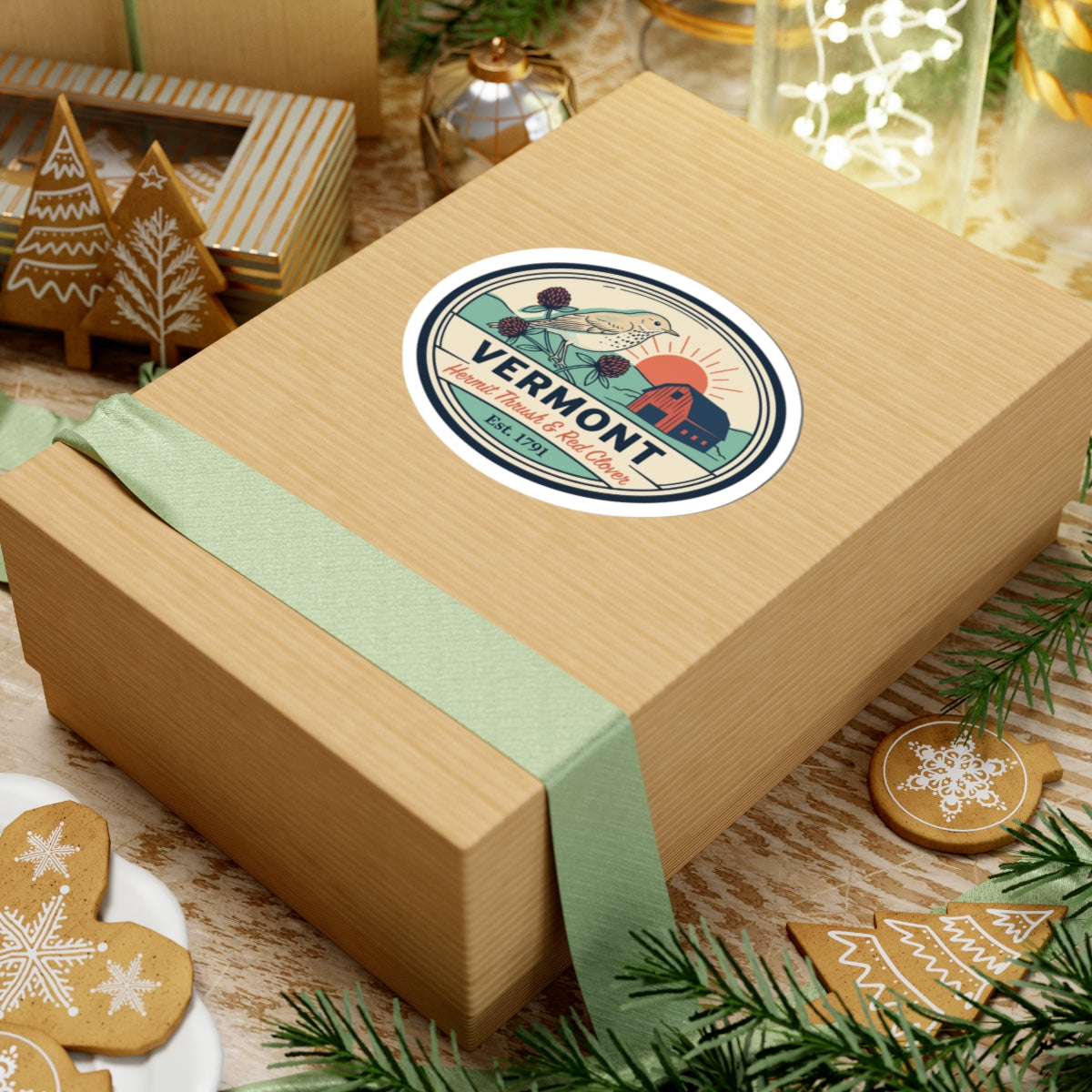 Vermont sticker on a gift box top with green ribbon and holiday decorations
