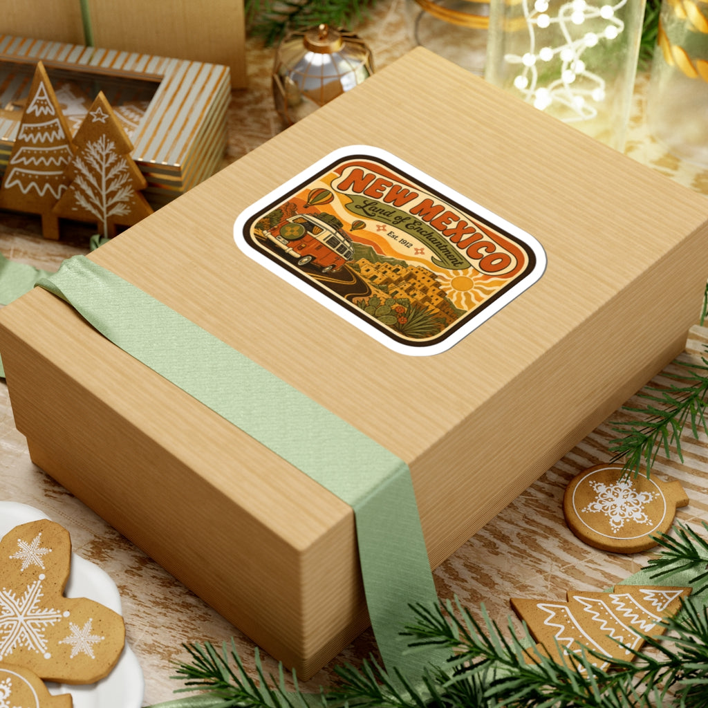 Die-cut New Mexico Land of Enchantment sticker with vintage camper, desert town, road, and sun