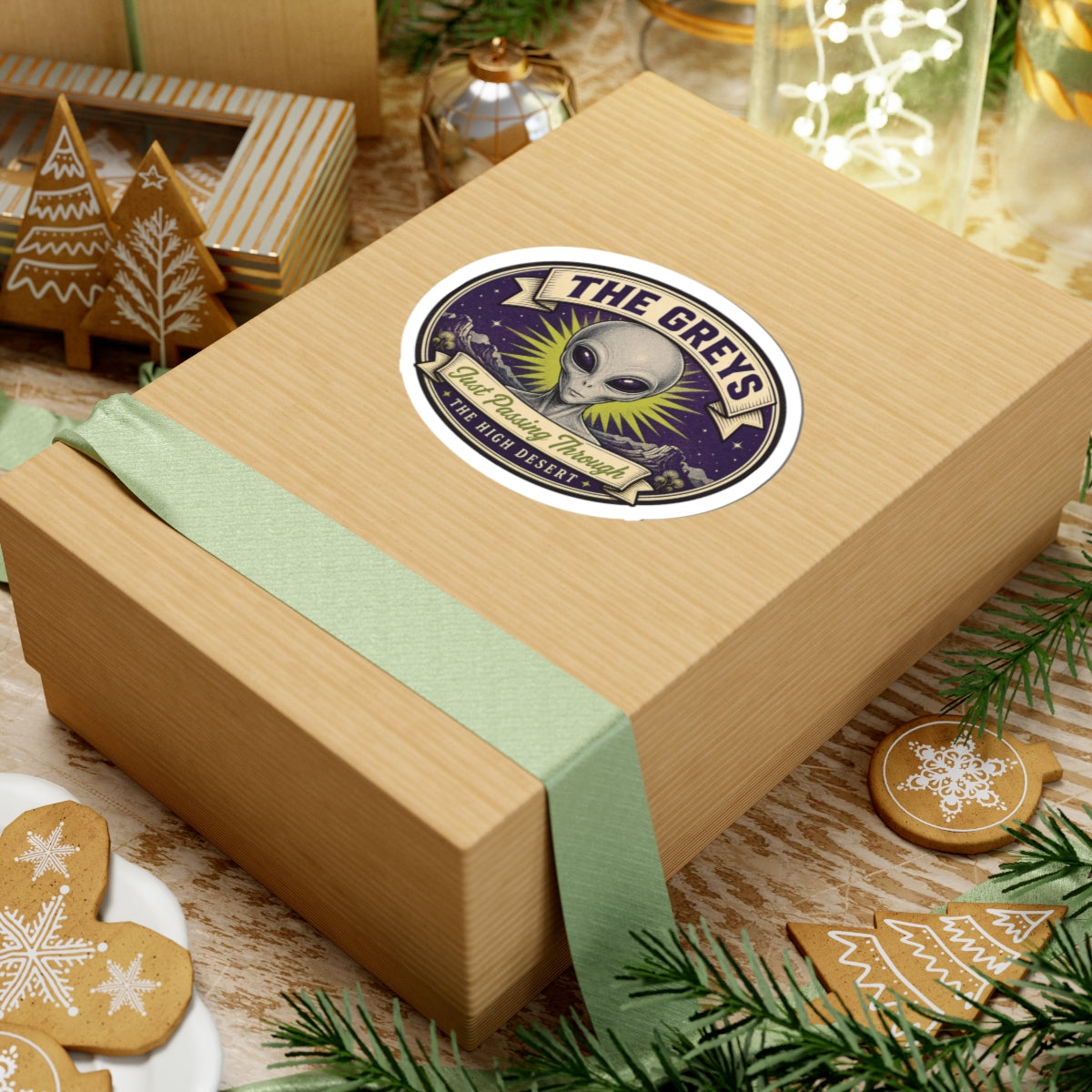 Alien head round sticker on a wooden gift box with mint ribbon and space illustration