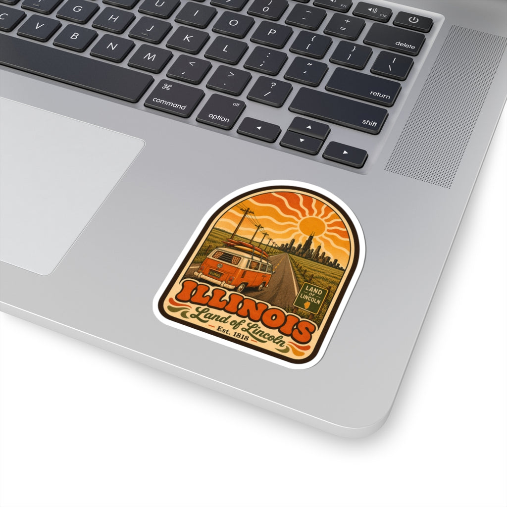 Kiss-cut sticker on laptop keyboard: orange camper van, Illinois lettering, and Land of Lincoln
