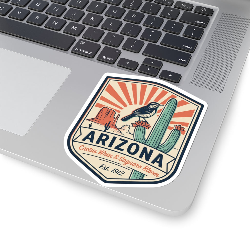 Arizona sticker badge on a laptop lid with cactus wren and saguaro bloom, Est. 1912.