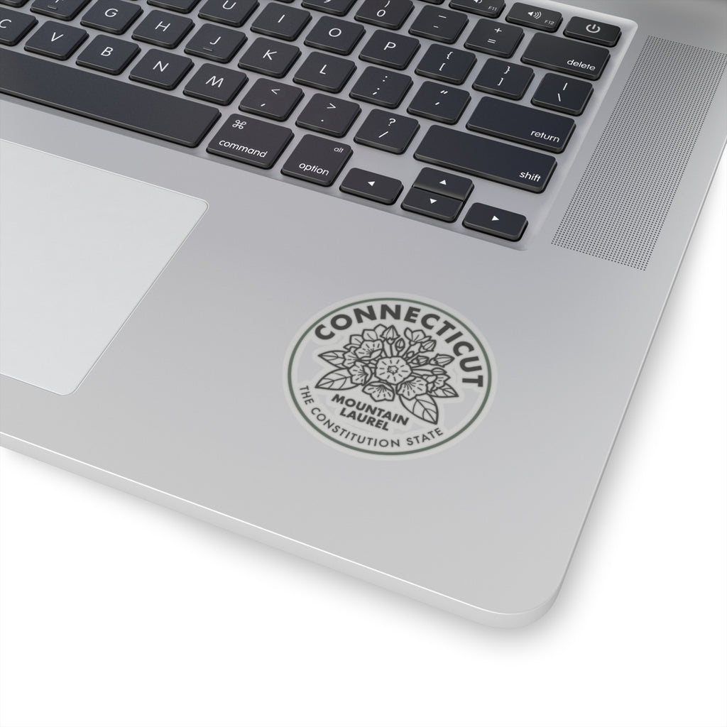 Circular Connecticut seal sticker with mountain laurel line art on a laptop lid