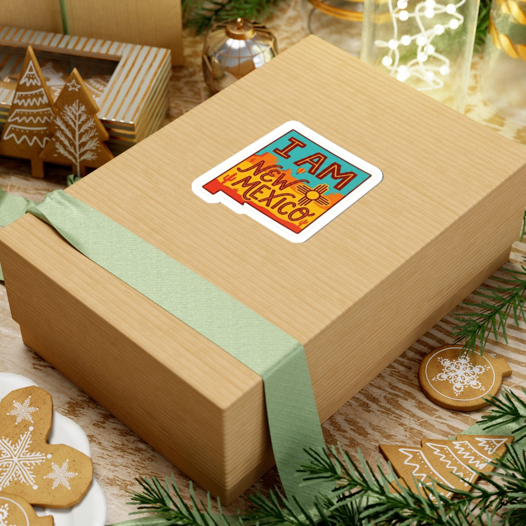New Mexico sticker on gift box: “I AM” and “NEW MEXICO” teal/orange desert with sun