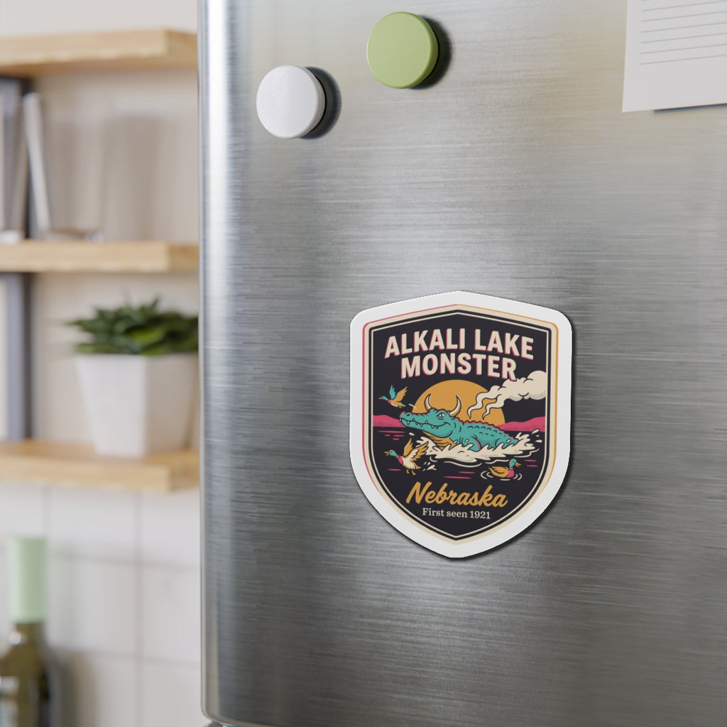 Shield die-cut magnet with colorful Alkali Lake Monster artwork and Nebraska text