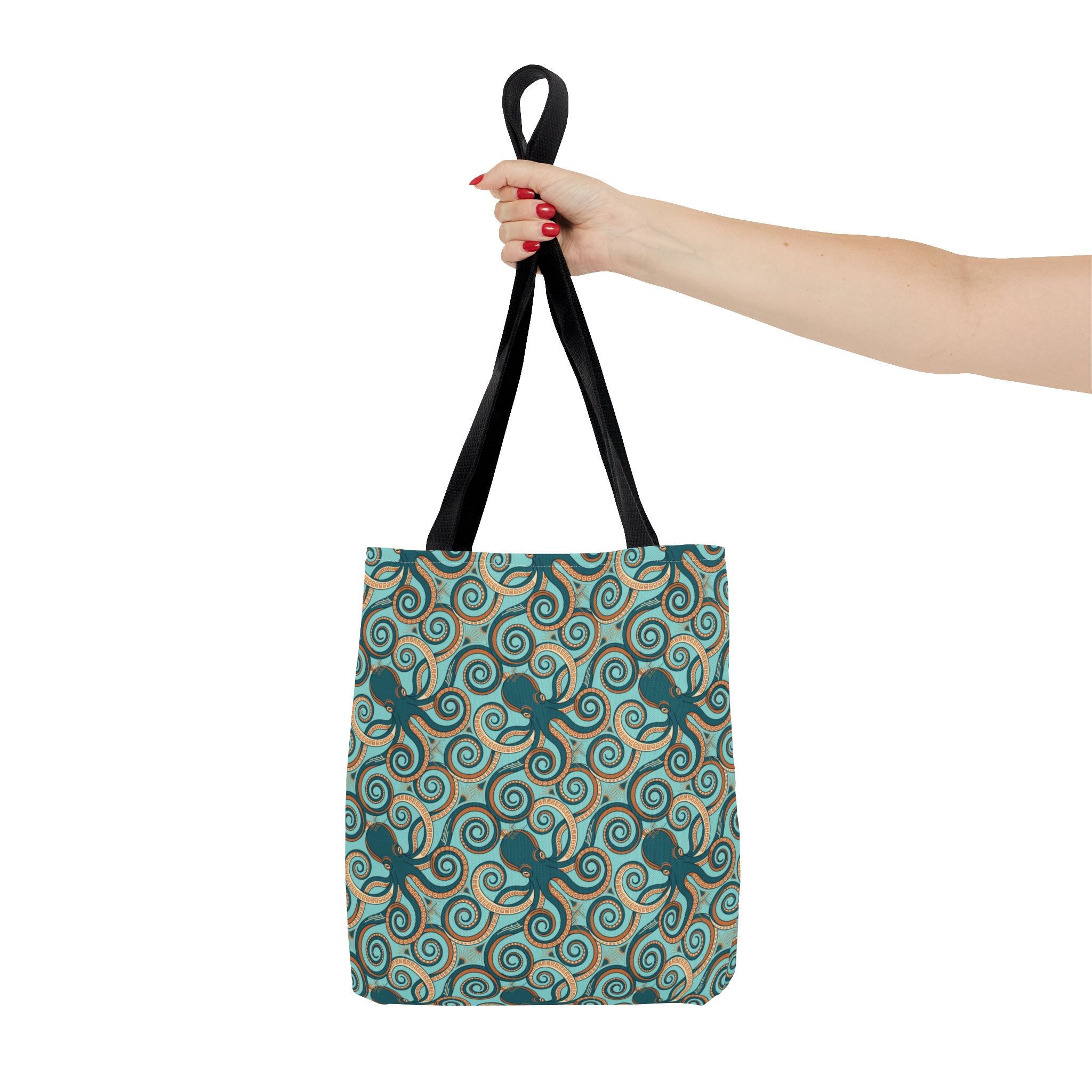 Octopus swirl tote bag with teal all-over print, held by hand, black handles