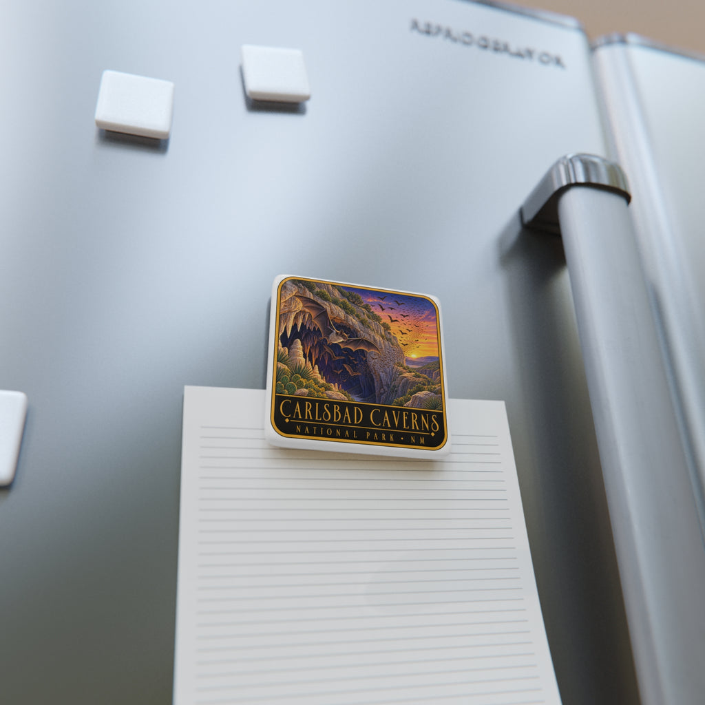 Square porcelain fridge magnet with bat cave artwork resting on paper