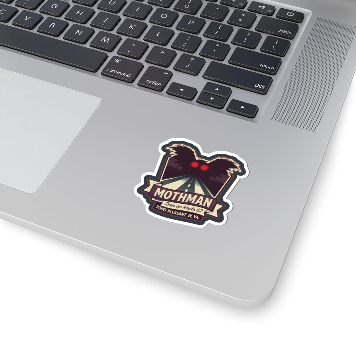 Kiss-cut sticker of Mothman with red heart and black wings on white backing