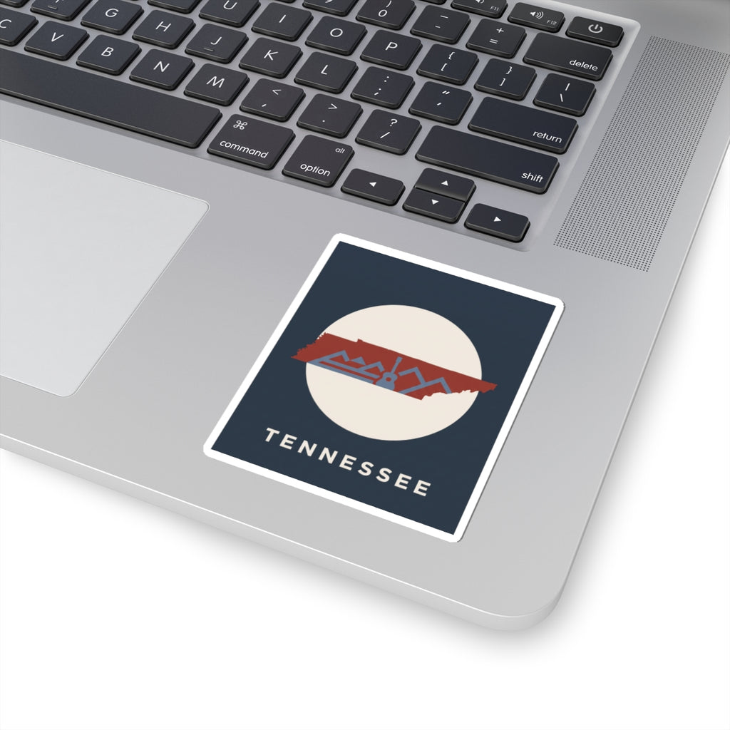 Tennessee outline sticker with retro mountains and guitar, shown on a laptop keyboard