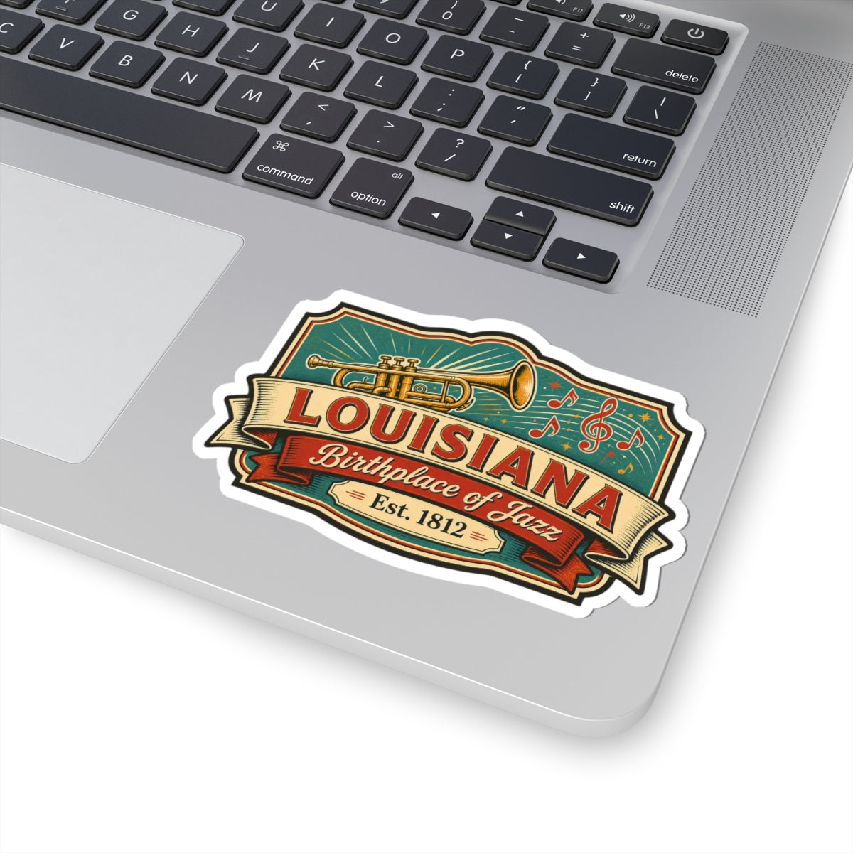 Louisiana jazz sticker on laptop lid with trumpet, music notes, and ribbon banner