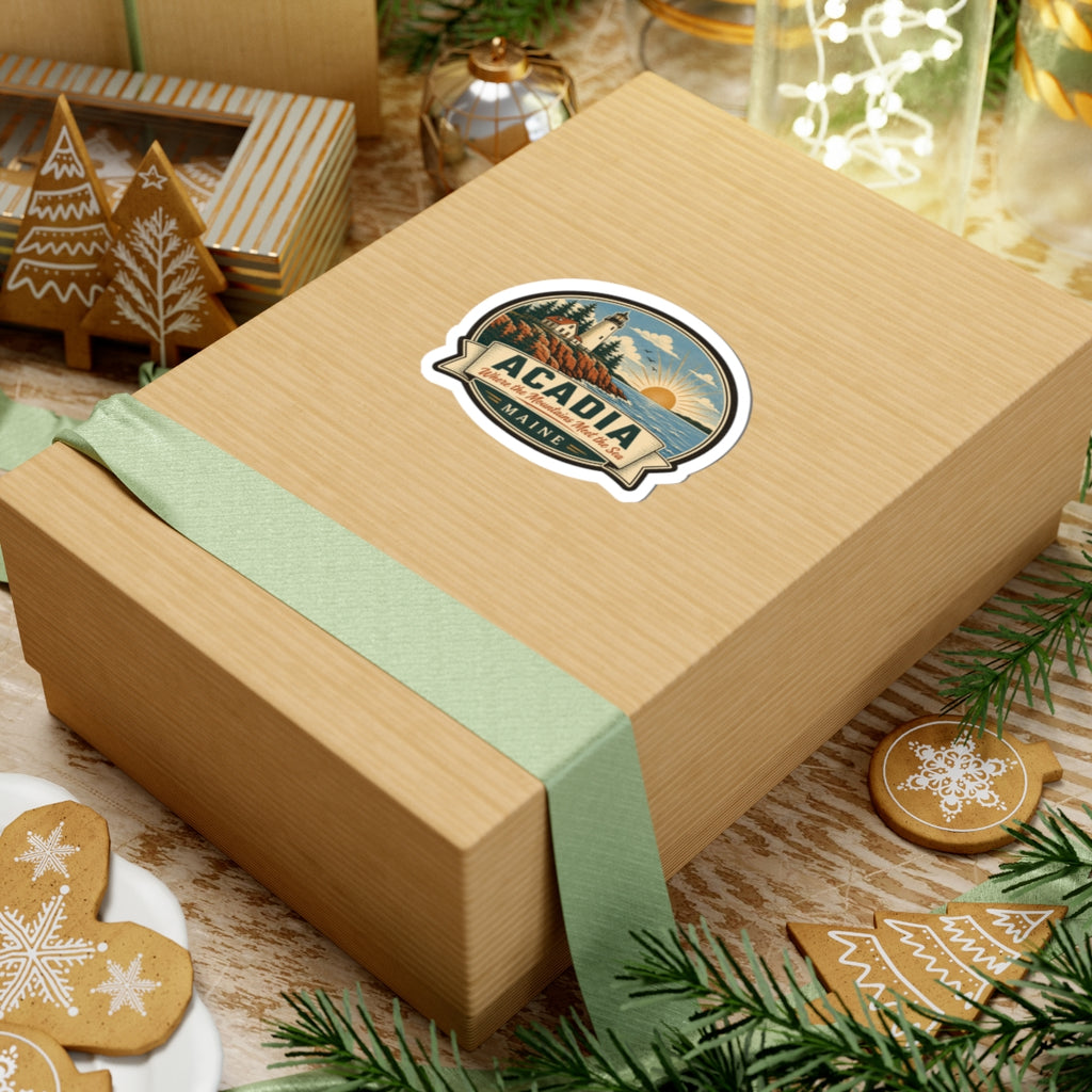 Round Acadia Maine travel sticker on a gift box: lighthouse, rocky coast, sunrise, 'ACADIA'.