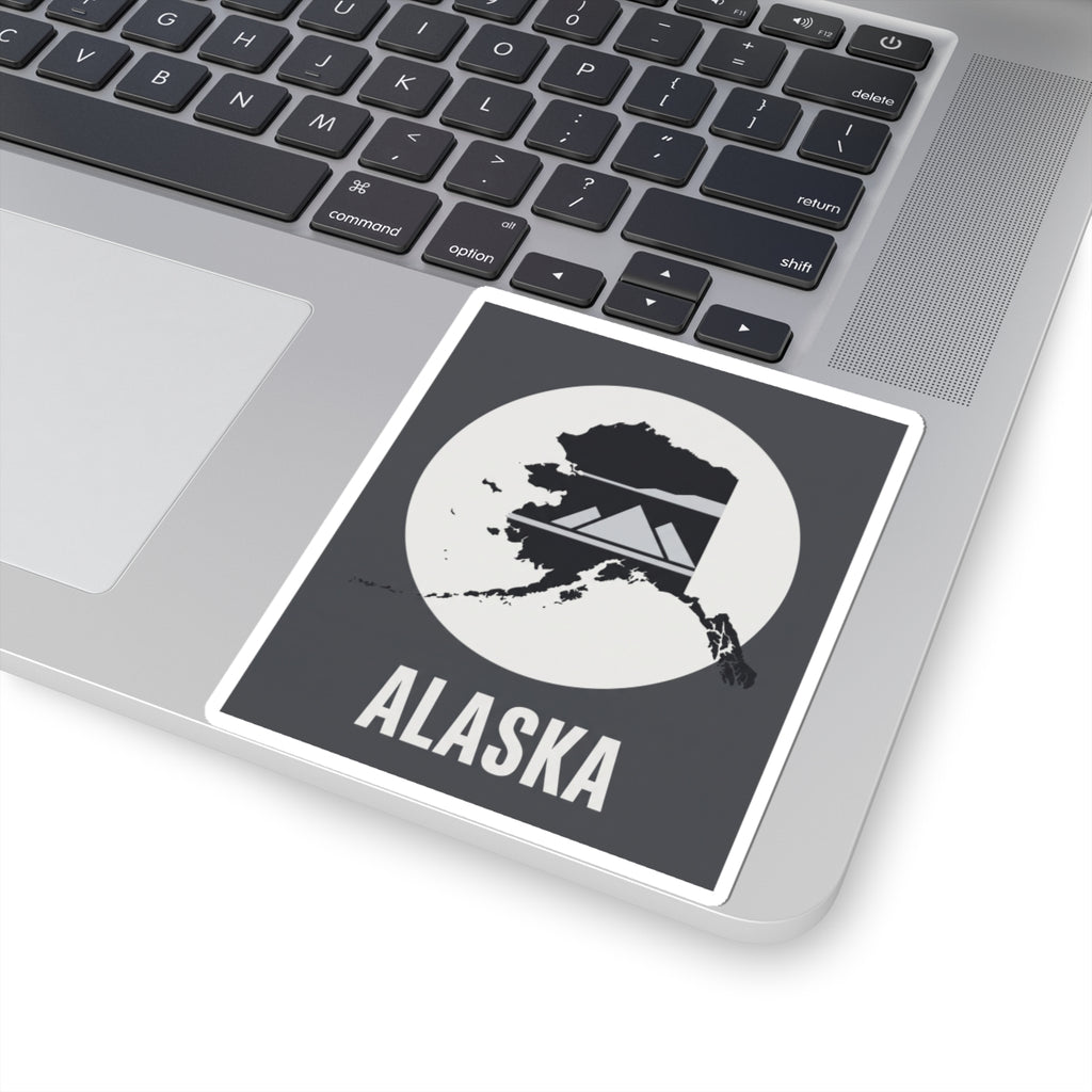 Alaska “ALASKA” text vinyl sticker on laptop surface, square dark gray and white design.