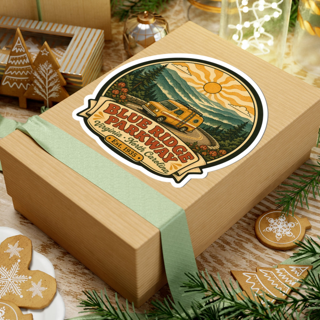 Die-cut sticker on gift box: vintage yellow camper van on winding road with sun rays and Blue Ridge Parkway text
