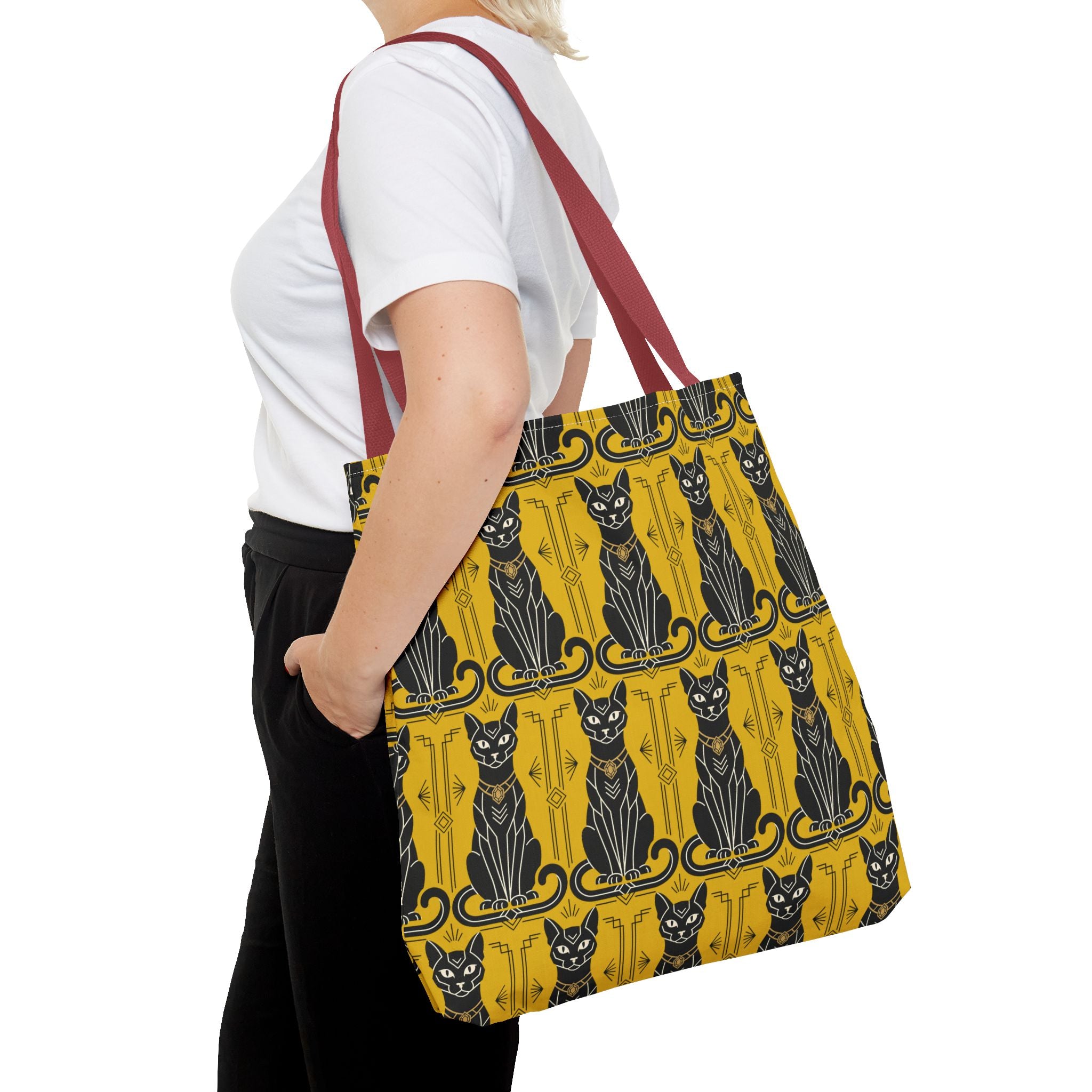 Yellow cat-pattern tote bag with black cats and navy swirls, carried on shoulder strap.