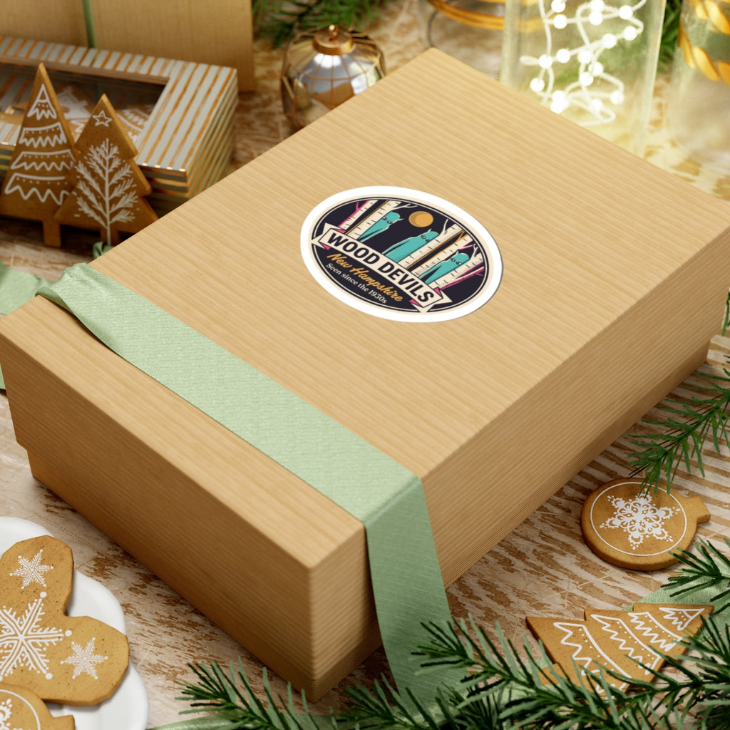Oval kiss-cut vinyl decal on gift box top featuring birch trees, teal figures, and gold moon