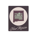Metal wall art sign with New Mexico emblem, sage green accents on dark background