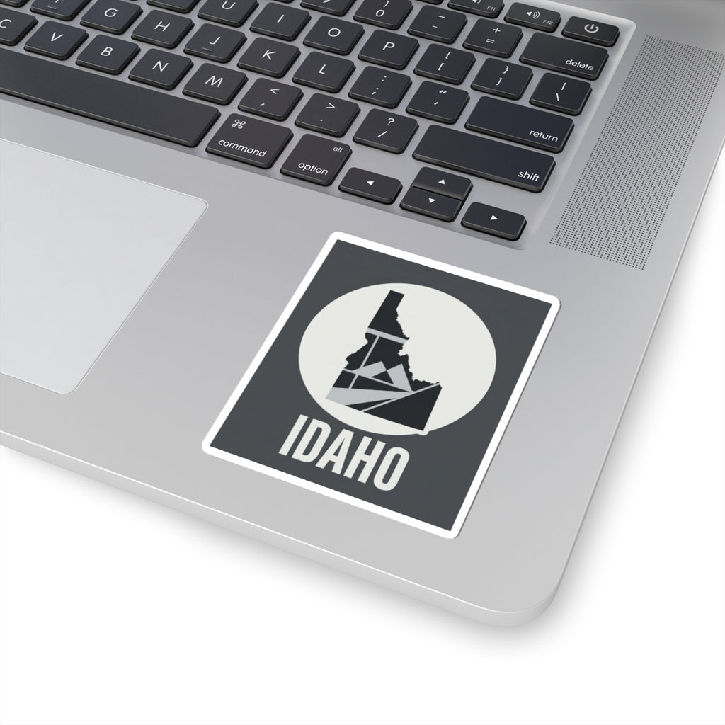 Idaho geometric map kiss-cut sticker, dark square with white circle, Idaho outline over mountain lines