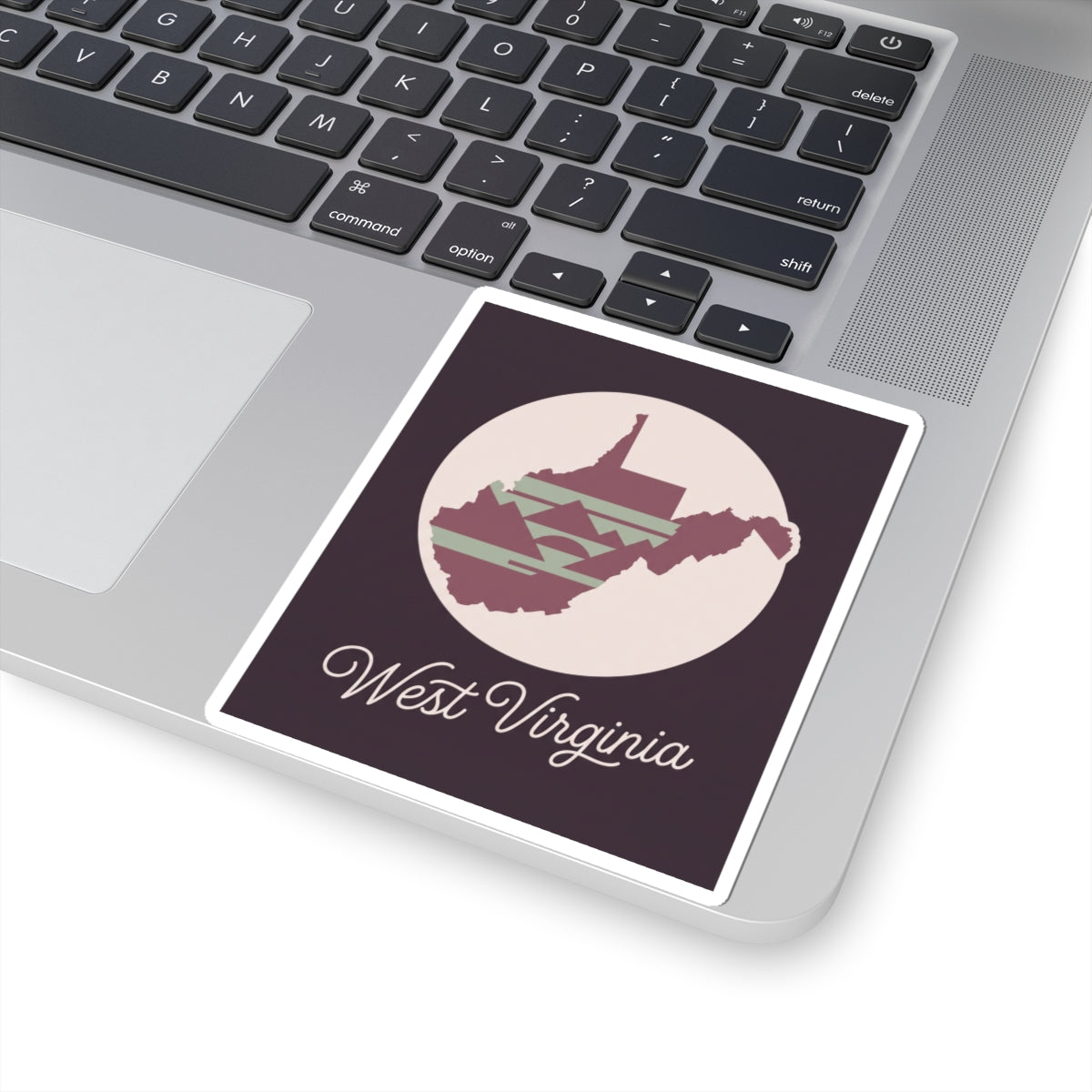 Kiss-cut West Virginia sticker on laptop: purple square with circular silhouette and “West Virginia”.
