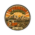Round kiss-cut vinyl sticker depicting Wyoming mountains, orange van, rabbit, “Forever West,” “Est. 1890”
