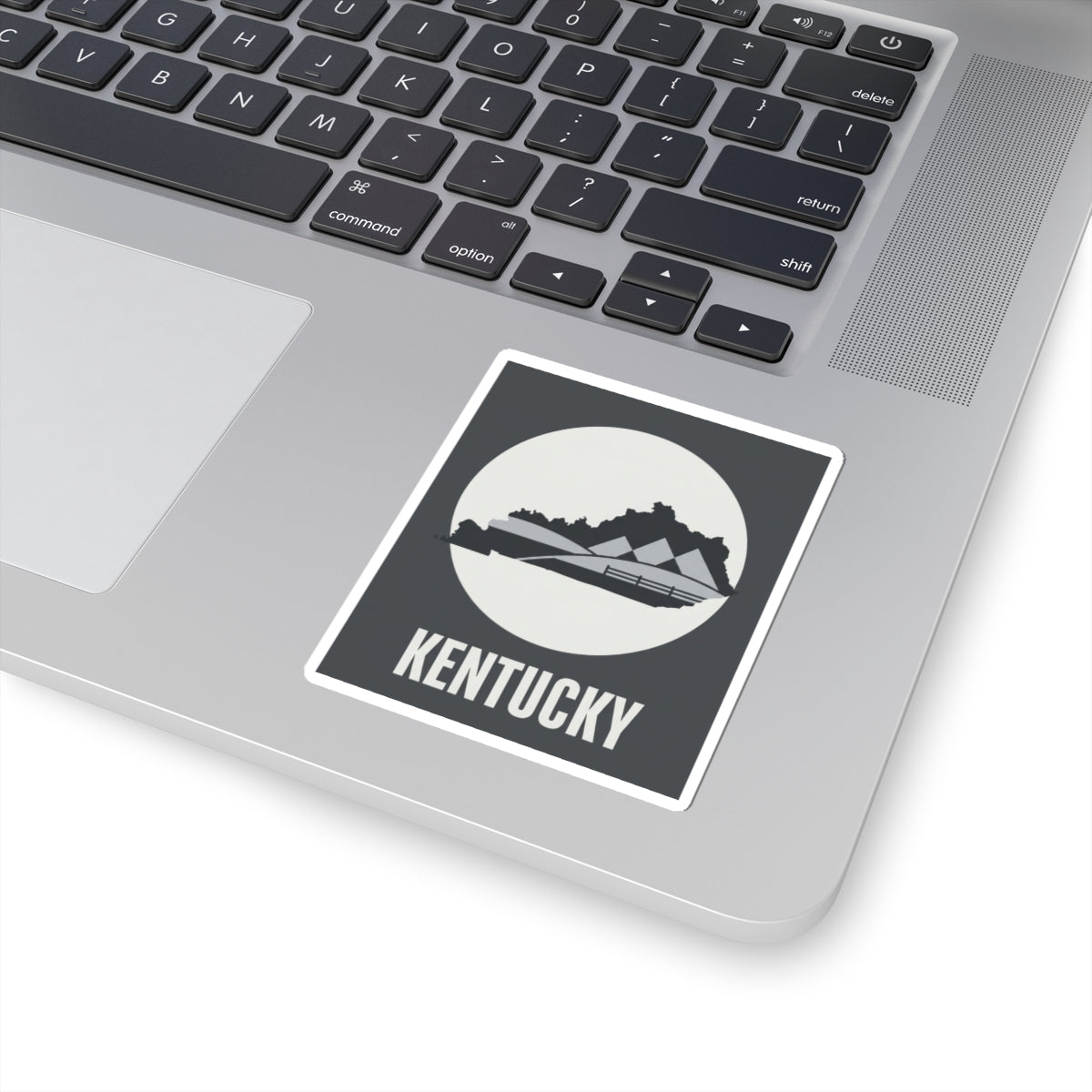 Kentucky vinyl sticker with white border on laptop, dark gray square and KENTUCKY text