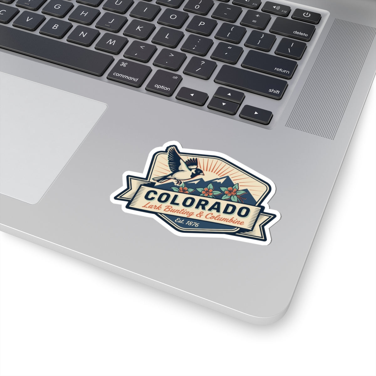 Colorado sticker decal on a laptop: bird over mountains with floral and Est. 1876 text