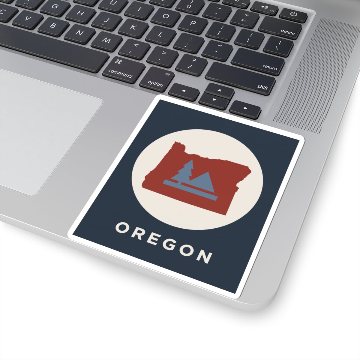 Square sticker design: red Oregon map with blue pine trees and mountain platform; OREGON.