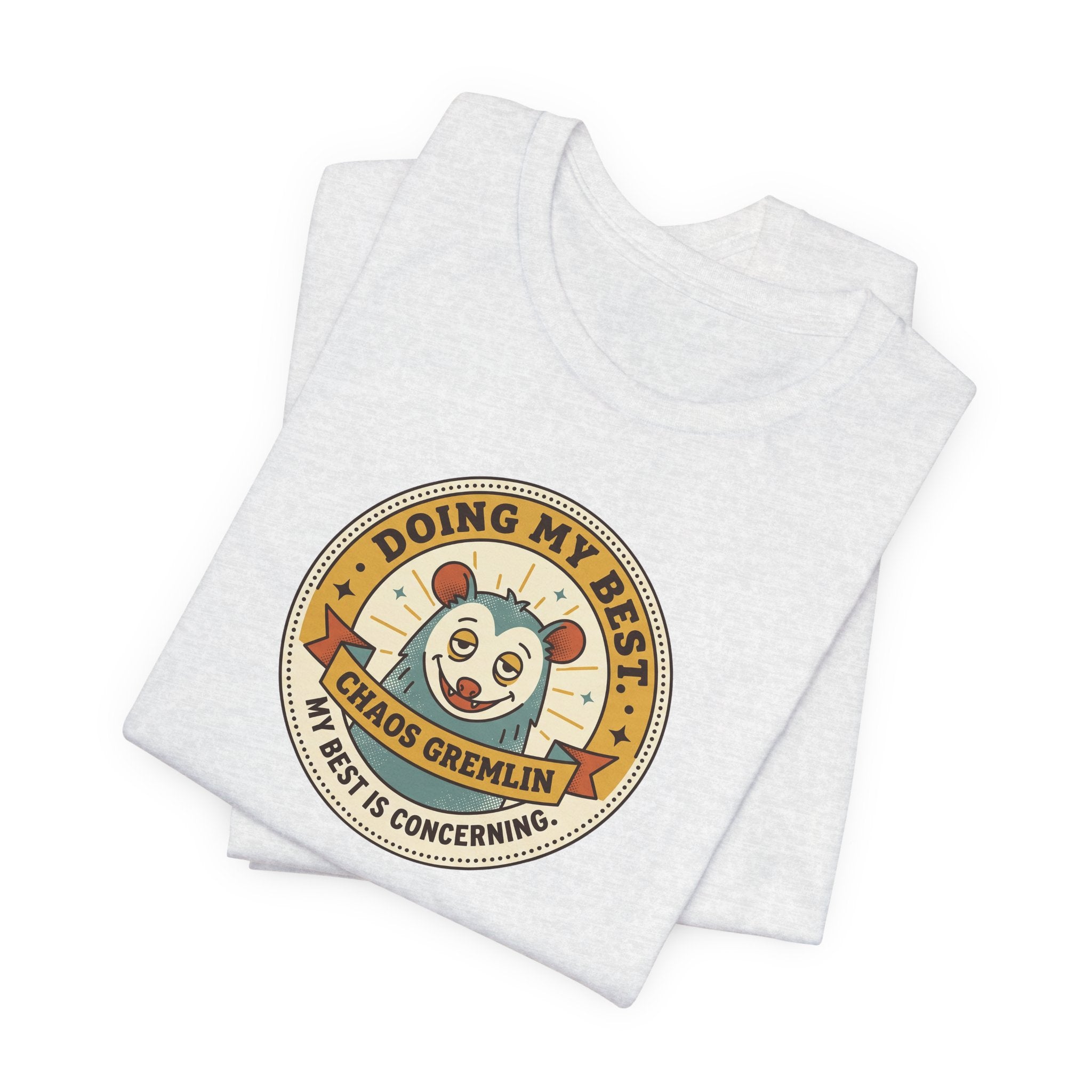 Heather grey T-shirt with round cartoon gremlin badge graphic on the chest