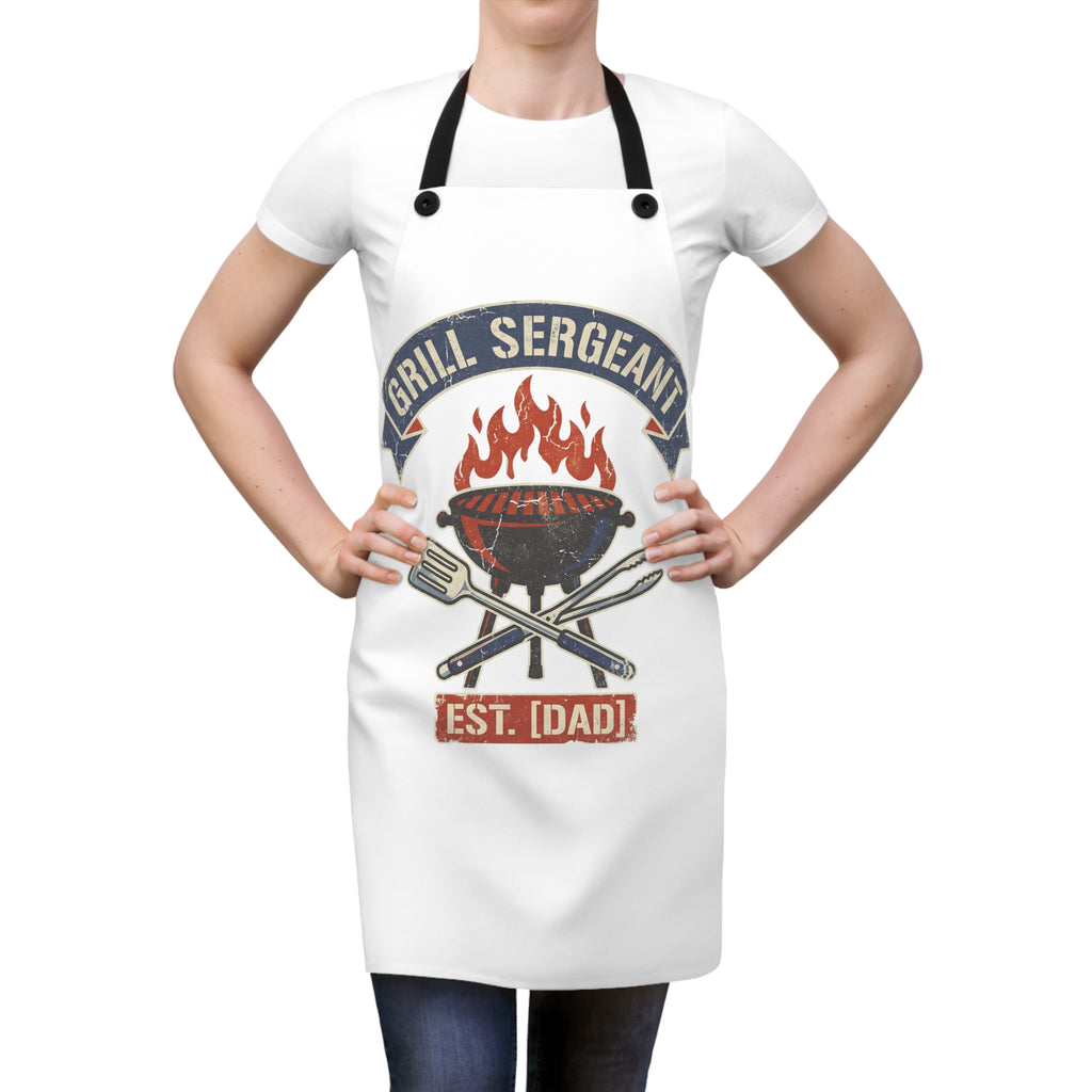 White apron worn over a T-shirt with black straps and flame grill badge