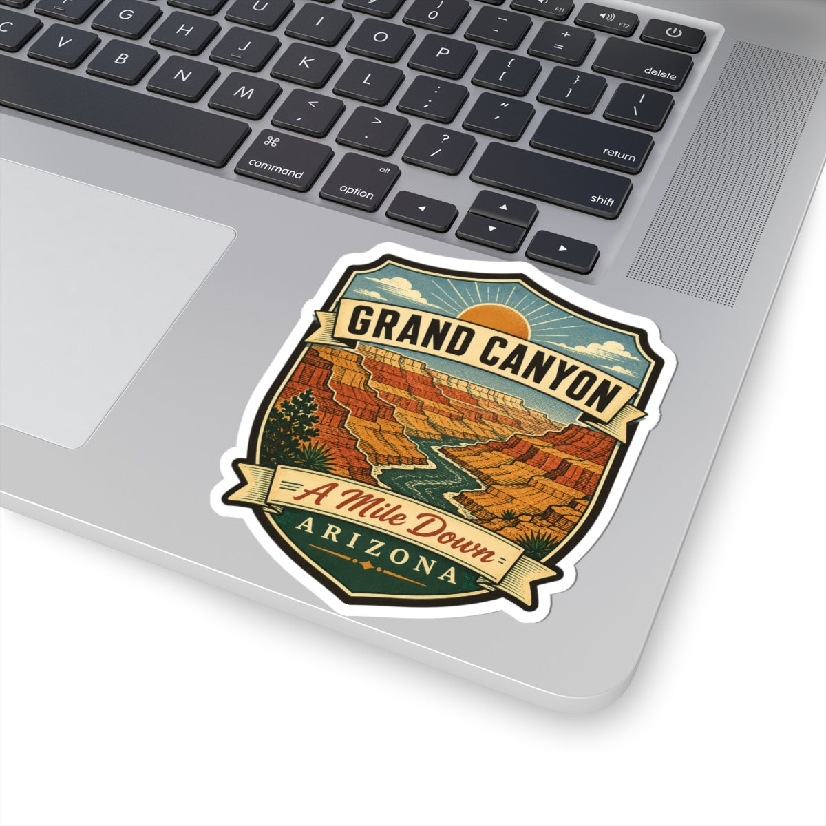 Shield-shaped travel sticker with “GRAND CANYON,” “A Mile Down,” “ARIZONA,” and canyon illustration.