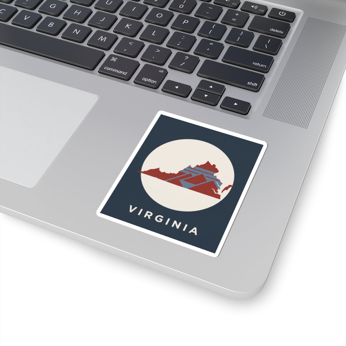 Virginia decal on laptop surface: red geometric Virginia map in cream circle with VIRGINIA text