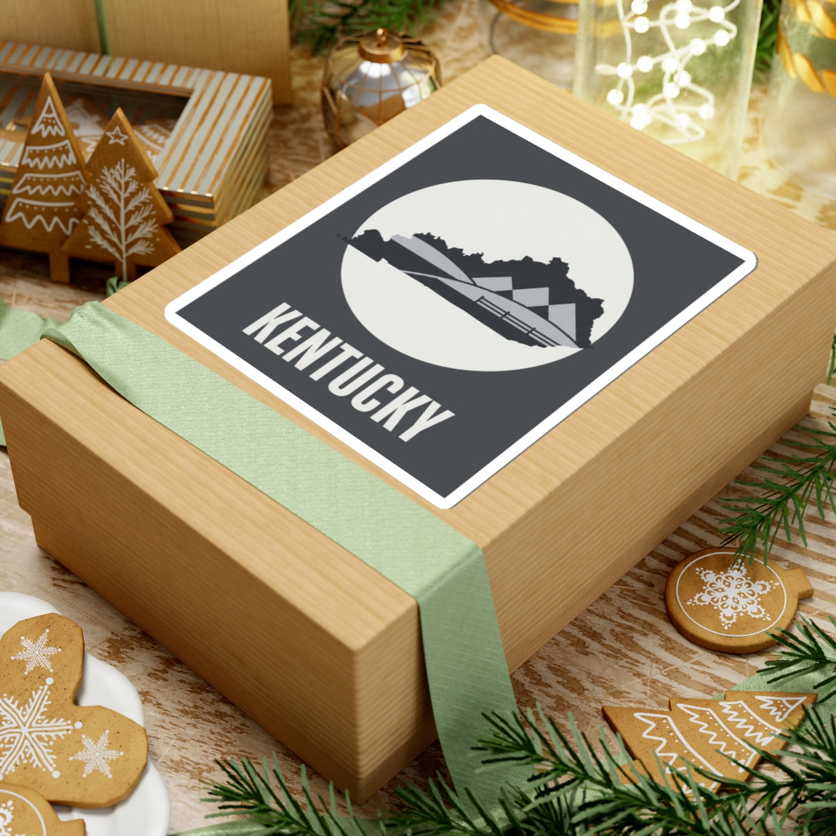 Kentucky vinyl sticker on wrapped present, dark gray square with white border and KENTUCKY