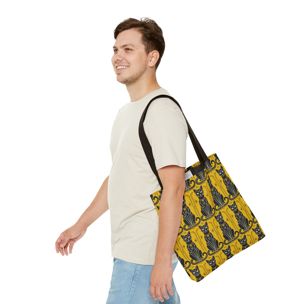 Yellow tote bag with repeating black cat print and ornate border; worn across shoulder