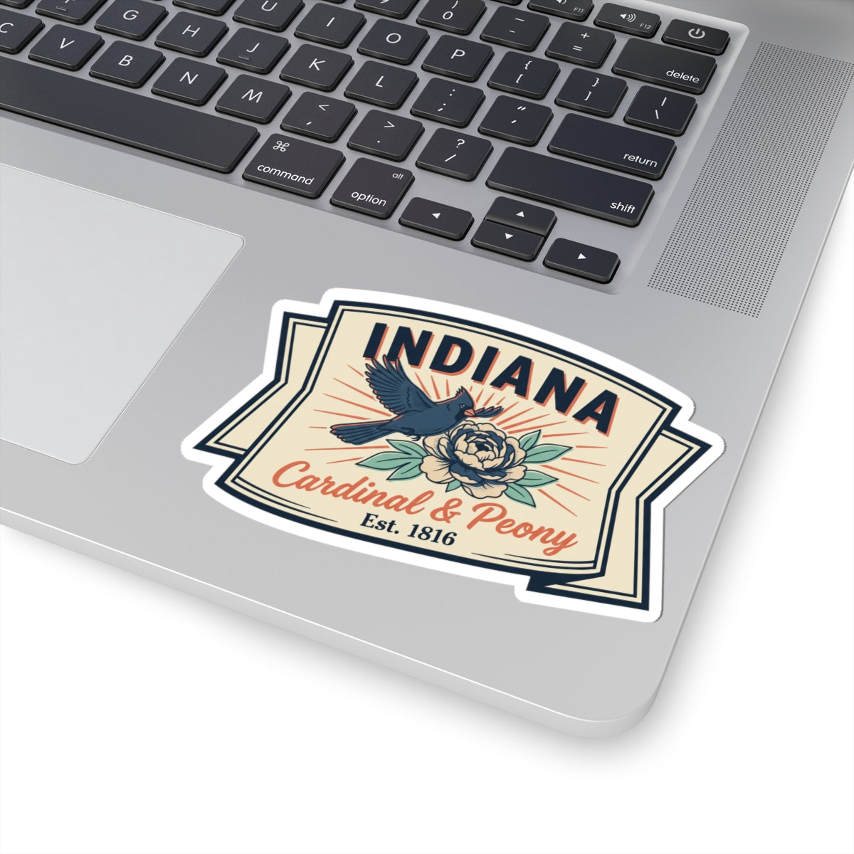 Indiana badge vinyl sticker on a laptop lid with cardinal and peony flowers.