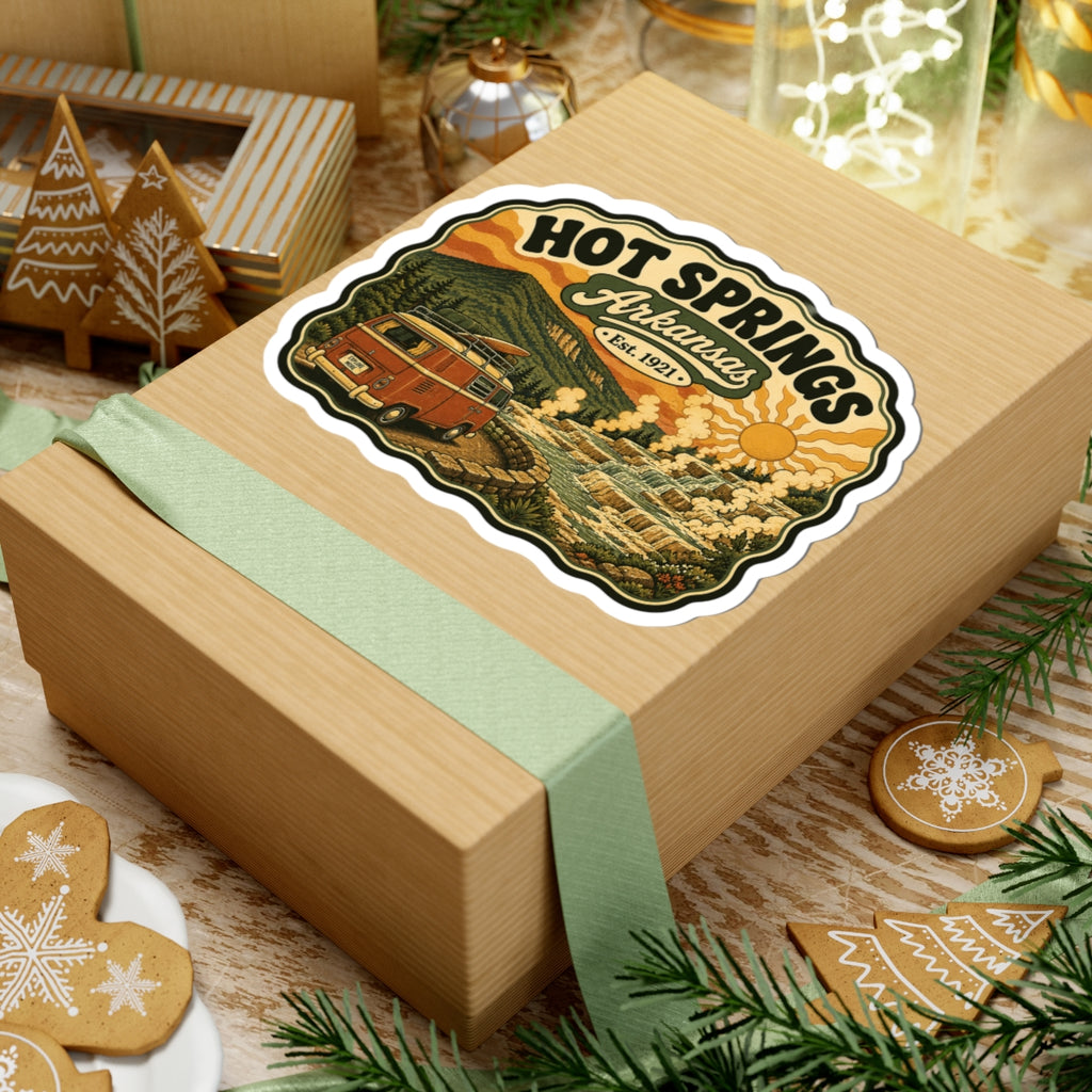 Die-cut Hot Springs Arkansas sticker on a wrapped gift box, vintage camper van and spring landscape