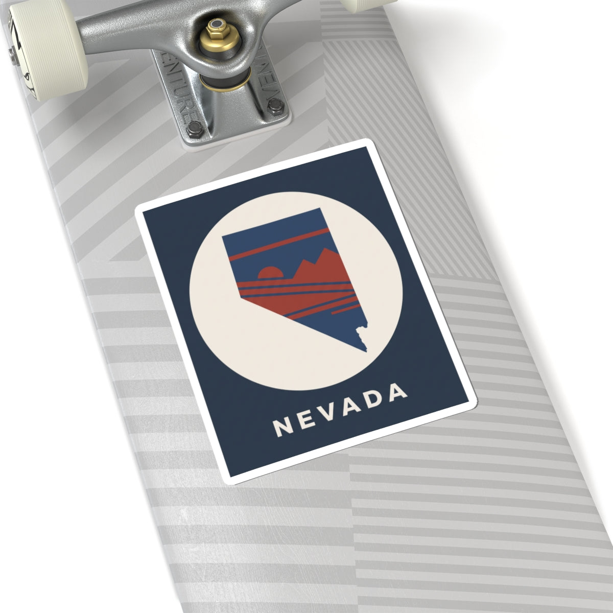 Nevada state kiss-cut sticker on a laptop surface, navy square with retro mountain emblem