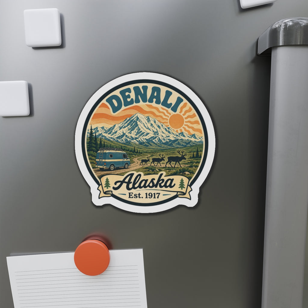 Round die-cut Denali Alaska fridge magnet shown on a dark refrigerator door