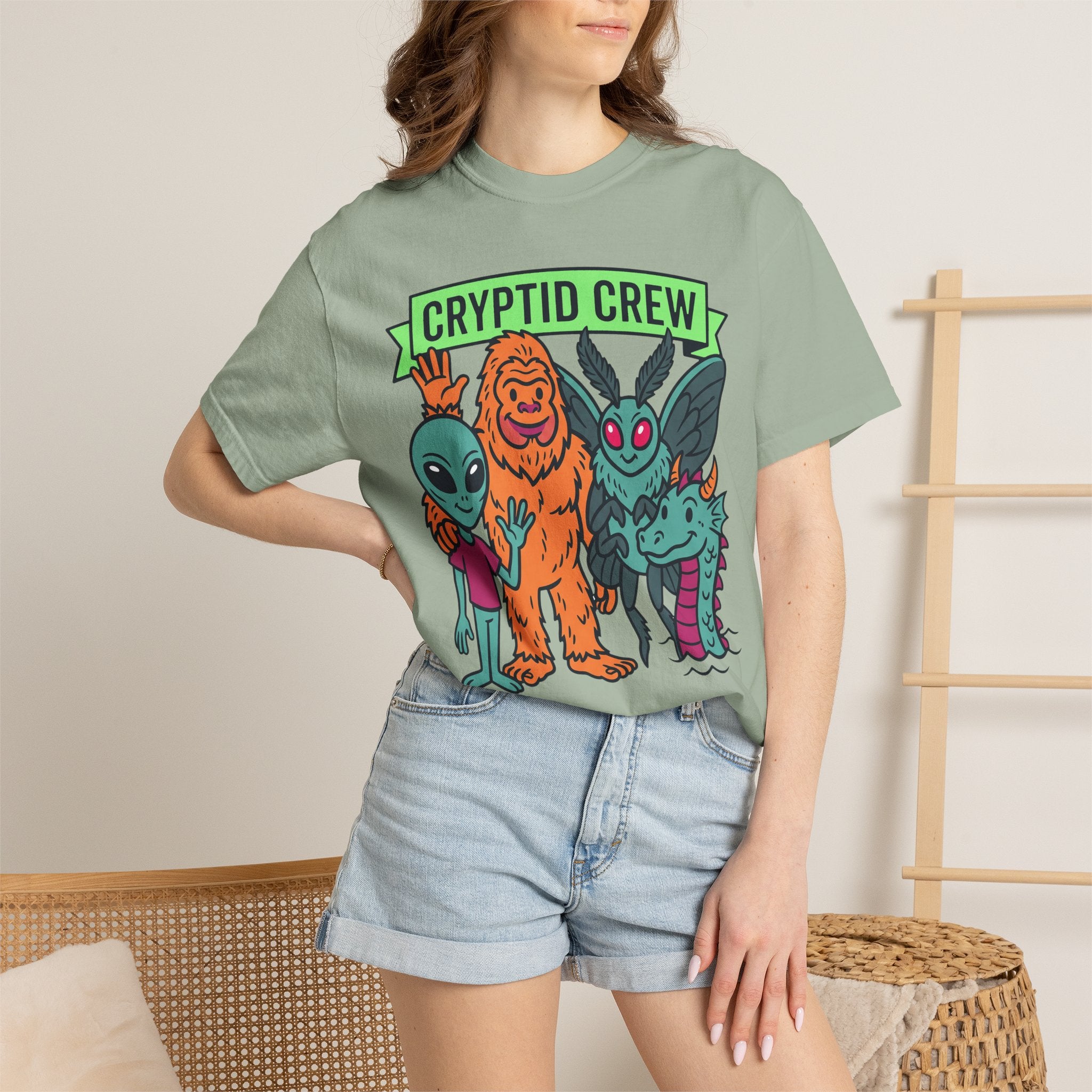 Mint green crew-neck T-shirt with 'CRYPTID CREW' graphic, worn by model.