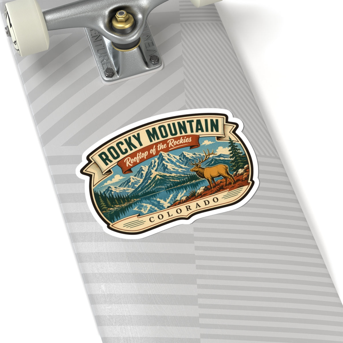 Travel sticker on a gray-striped envelope, with Rocky Mountain text, elk, and Colorado