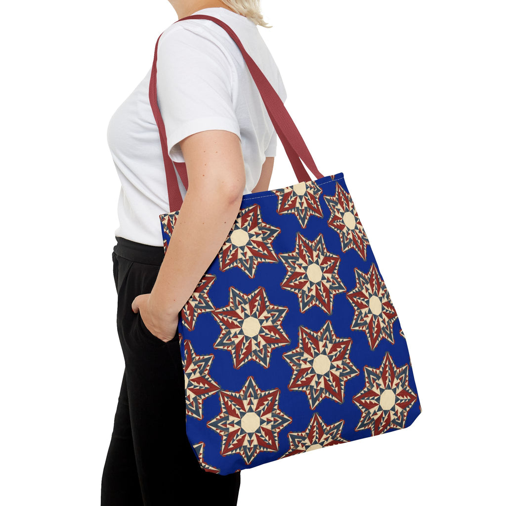 Blue starburst floral tote bag with burgundy straps, side view on a person
