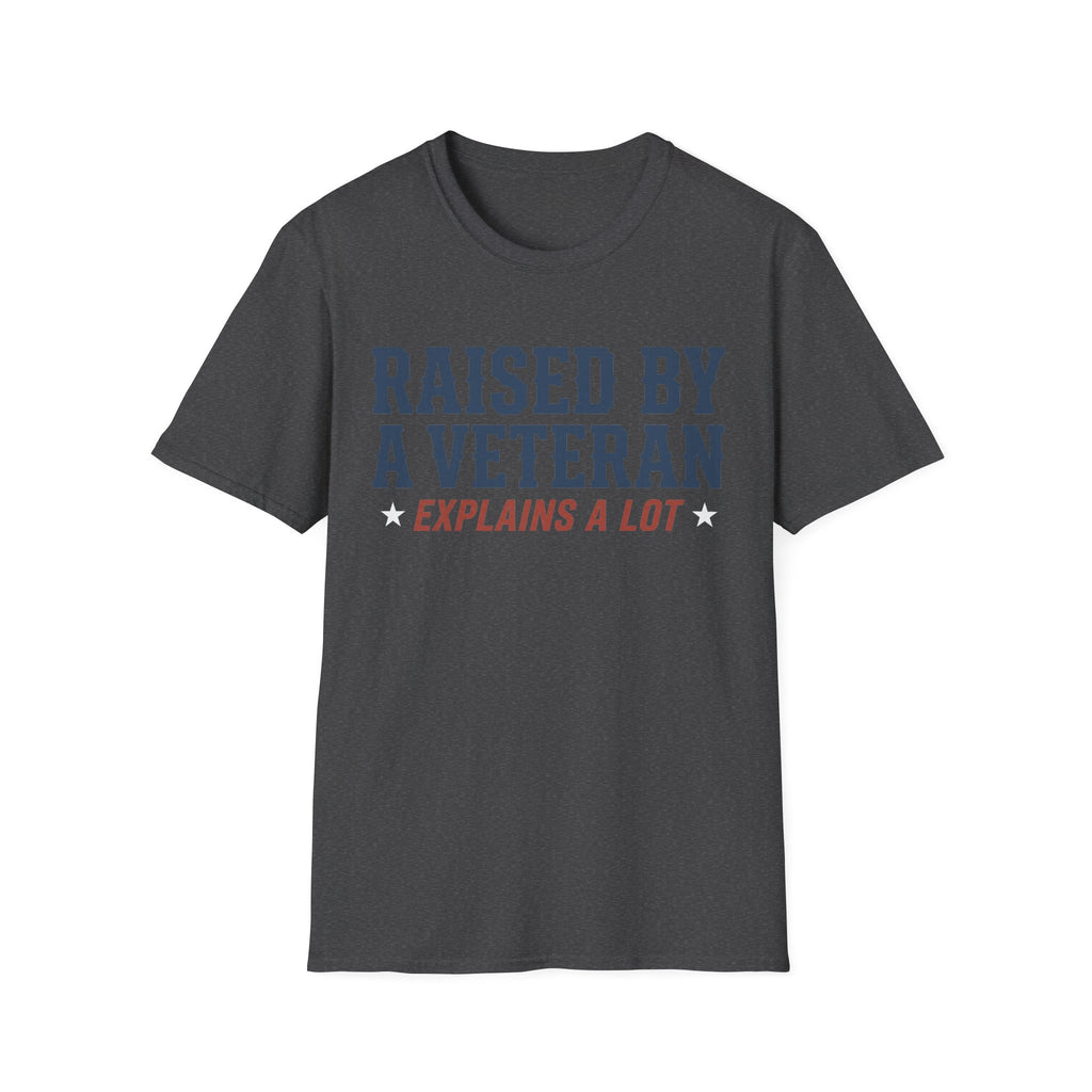 Dark charcoal crewneck T-shirt with 'RAISED BY A VETERAN' and 'EXPLAINS A LOT' graphic