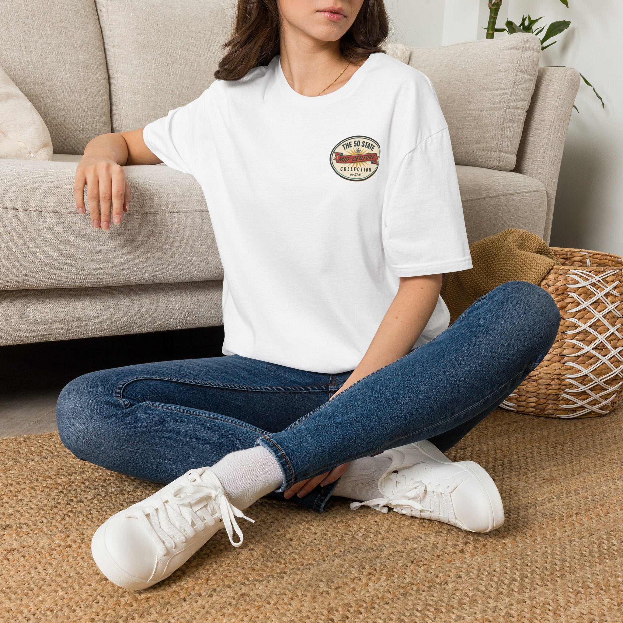 White graphic t-shirt with circular state badge, worn by woman