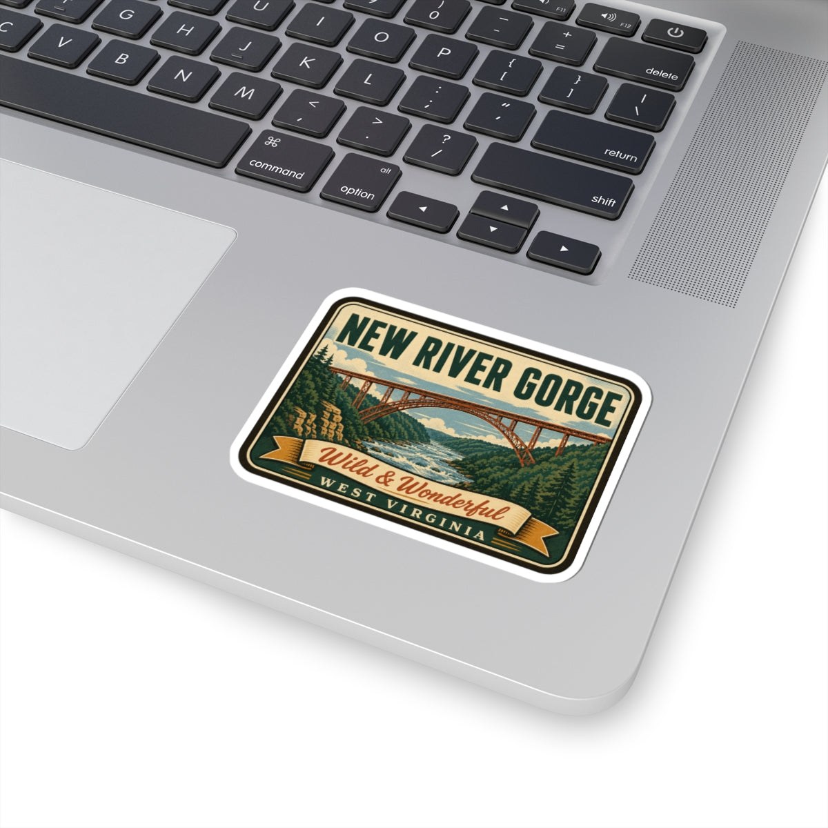 Travel sticker on laptop palm rest: New River Gorge bridge with Wild & Wonderful West Virginia text