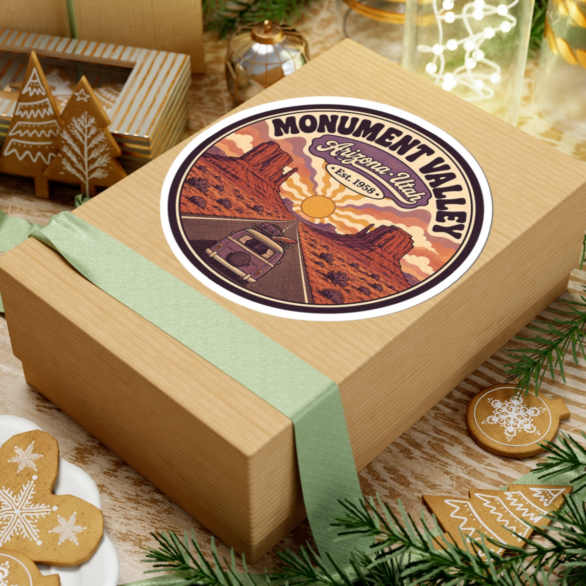 Round Monument Valley sticker on gift box lid with desert mesas, sun, and camper van road